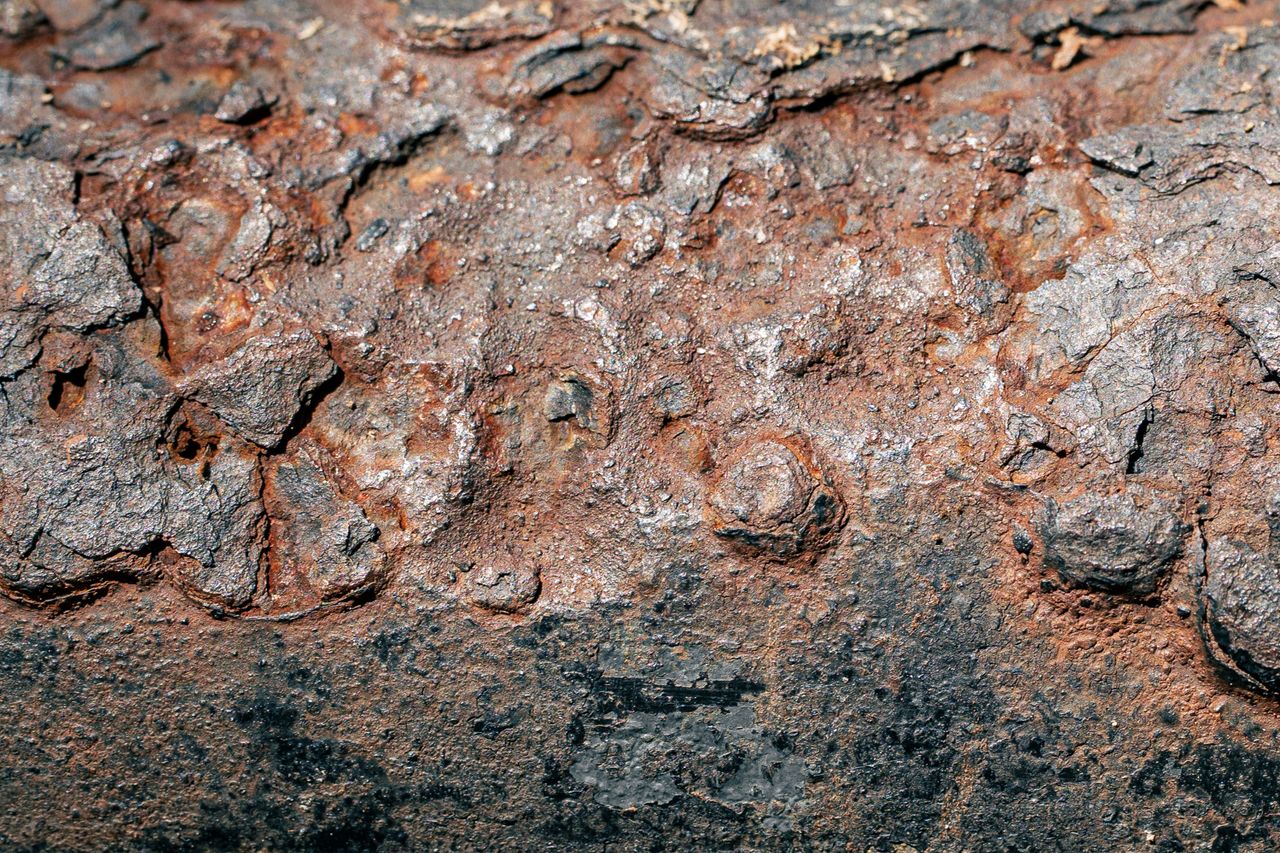 Detailed shot of rusty, corroded iron surface showing unique textures and colors, ideal for backgrounds.